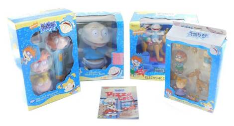 A Rugrats electronics coin bank., electronic Talking Room Guard., torch with three interchangeable character heads, poseable action figures, and Pizza Cats by Gail Herman. (5)