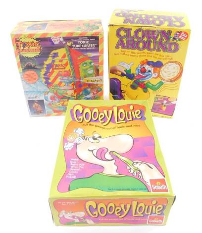 A Playmates Toxic Crusaders Turf Surfer, together with Goliath Gooey Louie and Pressman Clown Around. (3)