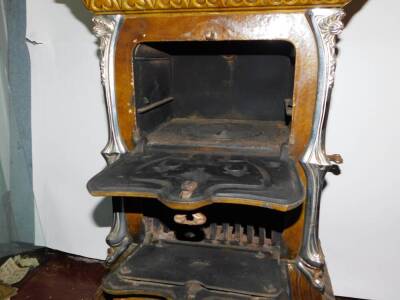 A French late 19thC Goudin cast iron polished metal and enamel stove, Model No 287., of serpentine form with a hinged cover and three floral moulded doors and drawers, raised on cabriole legs, 85cm high, 50cm wide, 38cm deep. Auctioneer Note: We have spec - 3