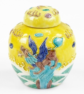 A Chinese porcelain ginger jar in the style of Wang Binrong, decorated in relief with a dog of fo seated on a rock among waves and water, on a yellow ground, Wang Binrong seal mark to base, 14cm high.