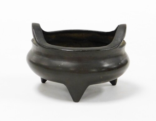 A Chinese cast bronze tripod censer with loop handles, cast Xuande seal mark to the base, 8cm high, 11cm diameter.