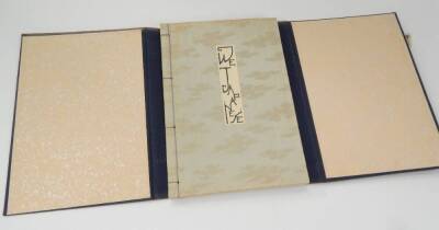 A copy of We Japanese, written by Frederic D E Garis, published for Fujiya Hotel Ltd Japan, with a glitter effect paper within outer canvas binding containing bone pegs.