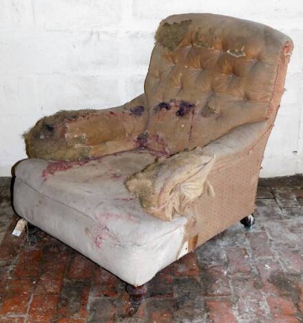 A Victorian deep seated and buttoned low armchair, in the manner of Howard & Sons, having turned forelegs.