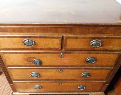 A George III oak and mahogany chest, of two short and three long graduated drawers, with mahogany cross banding oval pressed back plate handles, cluster column sides and bracket feet, 104cm high, 110cm wide, 53cm deep. - 2