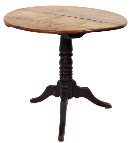 A Georgian oak supper table, with oval tilt top, turned pillar and three out splay legs, 71cm high, 87cm wide, 74cm deep.