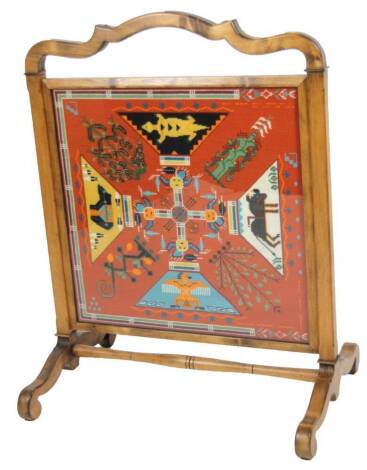 An early 20thC fire screen, with shaped handle and embroidered centre, on scroll feet joined by a turned stretcher, 102cm high, 80cm wide, 59cm deep.