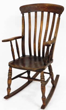 A early 19thC oak rocking chair, the shaped splat back on curved handles with bobbin turned legs, 115cm high, 60cm wide, 72cm deep.