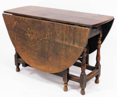 A late 19thC oak gateleg table, the two plank top with three plank flaps, on bobbin turned columns, with single frieze drawer, 72cm high, 113cm wide, 45cm deep without leaves.