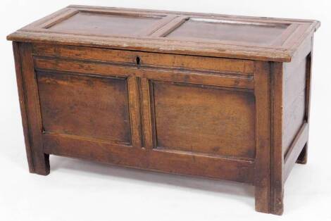 A 17thC oak coffer, the two panel top above two panelled sides, raised on stiles, 57cm high, 107cm wide, 47cm deep.