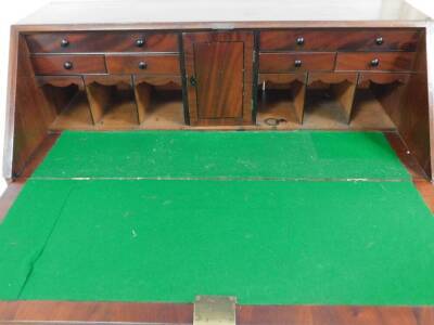 An early 19thC mahogany bureau, the fall flap opening to reveal drawers, cupboard and letters section, above four drawers, on bun feet, 121cm high, 100cm wide, 49cm deep. - 2