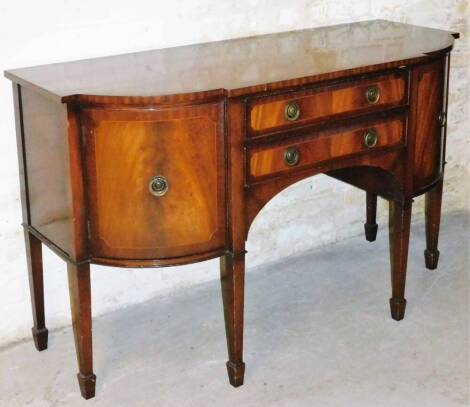 A George III style mahogany sideboard, the shaped top with a wide cross banding, raised above two frieze drawers with circular plate back handles, flanked by shaped cupboards on square taper legs terminating in spade feet, 92cm high, 153cm wide, 61cm deep