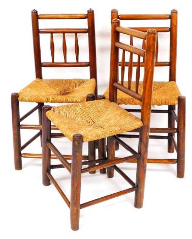 Three 19thC elm rush seated side chairs, with horizontal and cylindrical vertical backs and turned legs with double front stretchers, 88cm high. (3)