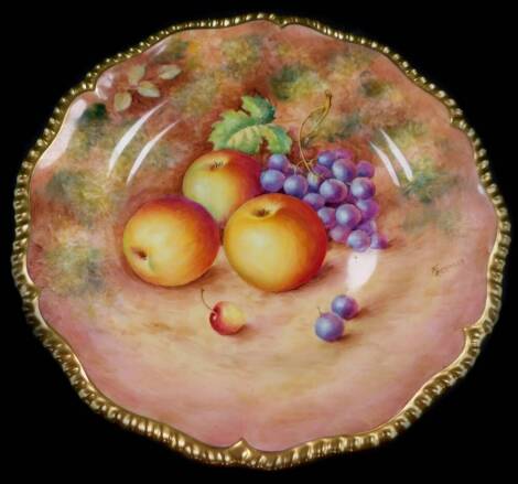 A Royal Worcester porcelain cabinet plate, signed Freeman, painted with apples and black grapes, 25cm diameter.