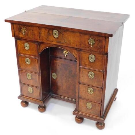 An early 18thC and later adapted walnut kneehole bachelor's secretaire chest, with folding top and raised on bun feet, 87cm high, 87cm wide, 58cm deep.