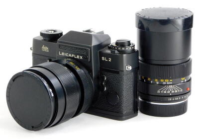 A black Leicaflex SL2 SLR camera, with a Leitz 35-70mm Vario-Elmar zoom lens, and a Leitz Elmarit R 135mm f2.8 telephoto lens, in camera case.