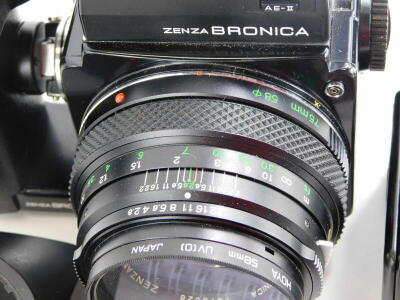 A Zenza Bronica ETRS SLR film camera, fitted with a Zenzanon 75mm f2.8 lens, with a Zenzanon 150mm f4 medium Telephoto lens, 120 and 35mm film back, a lens hood, and four instruction booklets. The camera features an AE-11E through the lens metering prism - 4