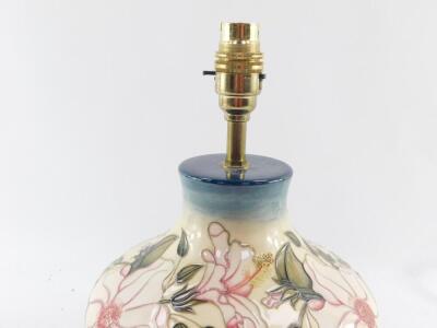 A Moorcroft pottery table lamp decorated in a floral pattern, of baluster form against a cream to blue ground, 27cm high. - 2