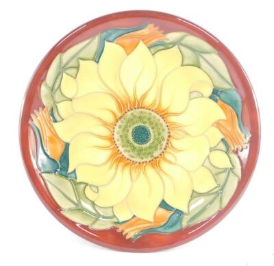 A Moorcroft pottery plate decorated in the Inca Sunflower pattern, painted and impressed marks, 26cm diameter.