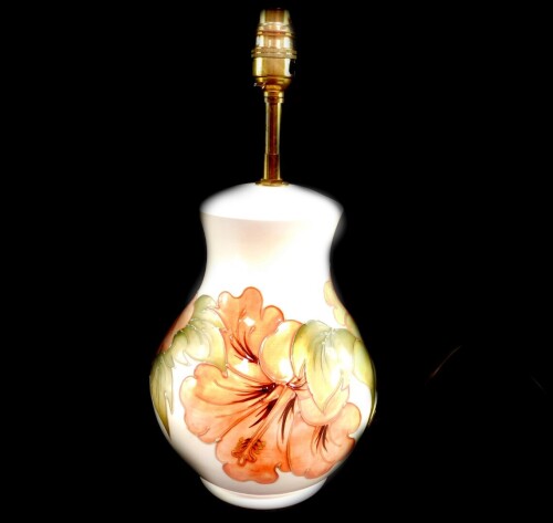 A Moorcroft pottery table lamp decorated in the Hibiscus pattern, of ginger jar and cover form, against a cream ground, impressed marks, 32cm high.