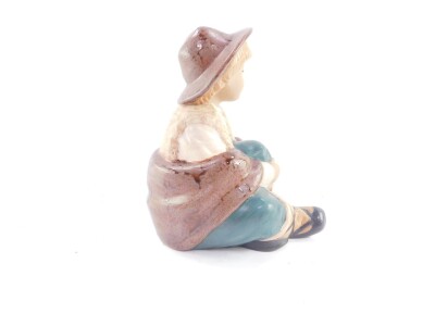 A Nadal matt pottery figure of a boy, modelled seated, printed marks, 22.5cm high. - 2