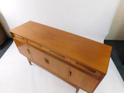 A G plan teak sideboard, with one long flanked by two short drawers, over four cupboard doors, raised on tapering square legs, 84cm high, 152cm wide, 45.5cm deep. - 2