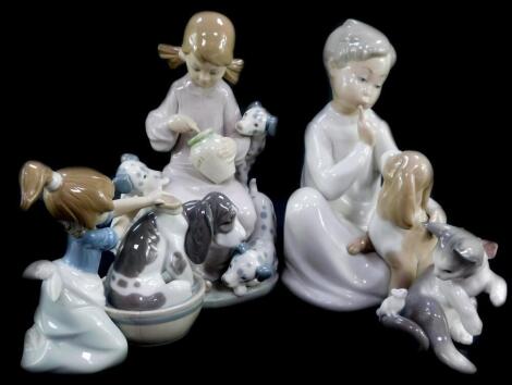 A Lladro porcelain figure modelled as Bashful Bather, boxed, together with Boy With Dog (AF), Honey Lickers, and a cat and mouse group. (4)