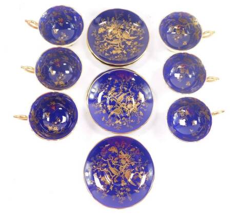 A set of six Coalport early 20thC porcelain teacups and saucers, gilt decorated with exotic birds and insects, against a cobalt blue ground, pattern no 10129/0, printed and painted marks.