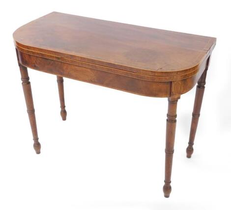 A George III mahogany demi lune folding card table, with cross banded top, raised on turned legs, 70cm high, 92cm wide, 46cm deep.