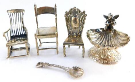 Three miniature models of chairs, white metal stamped 925, comprising a rocking chair, bar back chair and a hall chair, together with a fluted shell shaped pedestal salt, surmounted with a cherub, with spoon, stamped 925, 2.15oz.