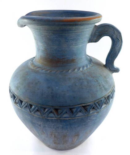 A large grey painted terracotta jug, with dog tooth decoration, 52.5cm high.