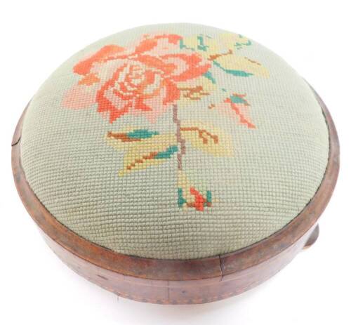 A Victorian walnut and inlaid foot stool, with floral wool work tapestry, raised on three bun feet, 27cm diameter.