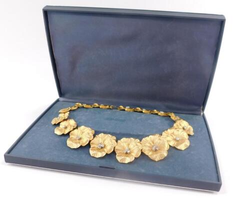 A mid century gilt metal and paste costume necklace, formed as graduated flower heads, on a hook clasp.