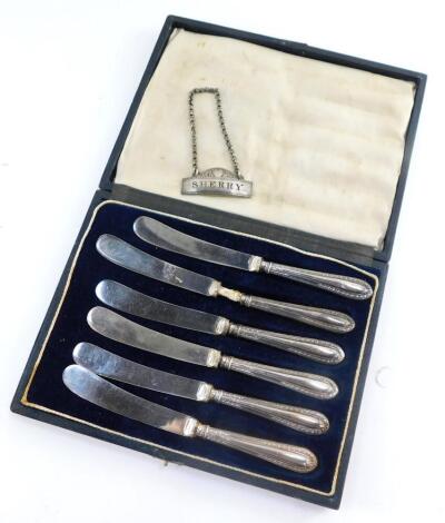 A Victorian silver sherry decanter label, William Summers, London 1875, and six George V silver handled cake knives, cased, Sheffield 1919, 4.72oz all in.