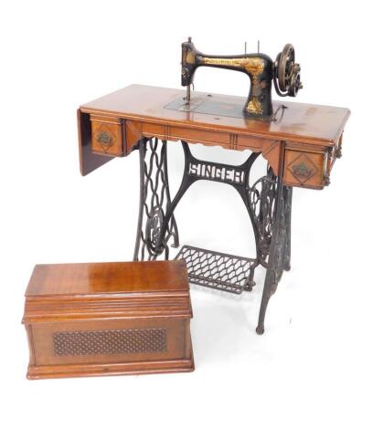 A Singer sewing machine table, with Egyptian model sewing machine, raised on a cast iron treadle base, 102cm high, 89cm wide, 41cm deep.