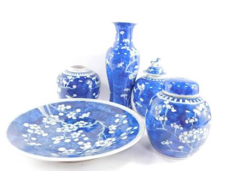 A group of Qing dynasty blue and white porcelain, decorated with prunus blossom against a cracked ice ground, composing, a baluster vase 25cm high, dish 28cm diameter, a pair of ginger jars and one cover, and a further ginger jar and cover with lying dog 