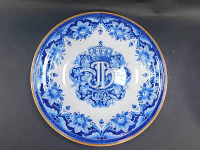 A Delft ware blue and white charger, commemorating the Silver Jubilee of HM Queen Wilhelemina, Queen of The Netherlands 1923, decorated with Coats of Arms beneath a crown with motto 'Je Maintiendrai Dispereert Niet', within a floral border, 34.5cm diamete - 3