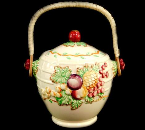 An A J Wilkinson Royal Staffordshire pottery biscuit barrel, with cane handle, moulded with fruit and leaves, printed mark.