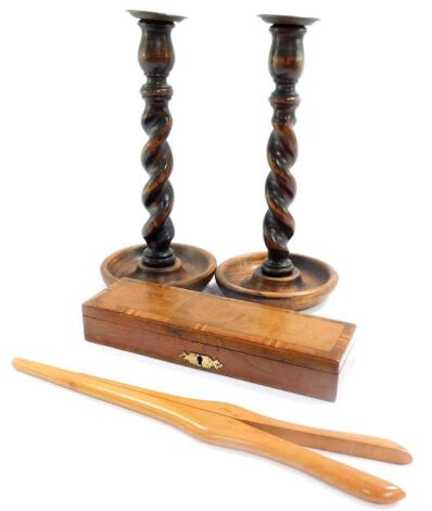 A pair of early 20thC oak barley twist candlesticks, with brass drip trays, a pair of Marshall & Snelgrove sycamore glove stretchers, and a mahogany and cross banded twin division pen box. (4)