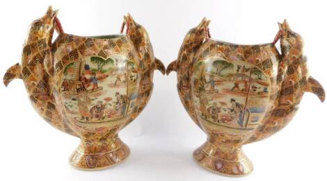 A pair of Chinese ceramic vases, of twin dolphin handle oval pedestal form, decorated with reserves of figures around a river setting, against a panelled ground, 41cm high.