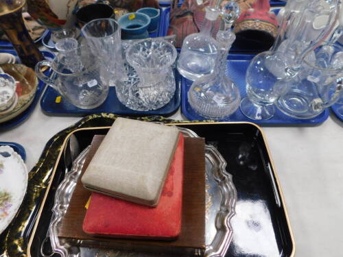Moulded glass ware, including a jug, etc., hobnail cut vases, bowls, decanters, cased flatware, a tin tray of shaped form, 52cm wide. (2 trays plus)