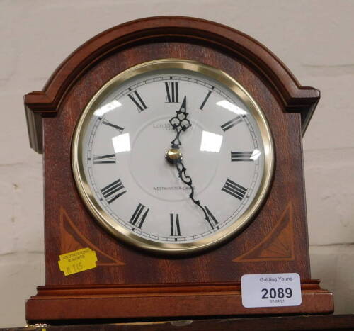 A London Clock Company Westminster Chime mantel clock, in shaped case with 12cm diameter Roman numeric dial.