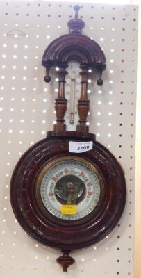 An early 20thC continental walnut cased barometer and thermometer, with arch thermometer above, 10cm dial and heavily carved case.