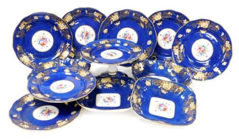 A Crown Staffordshire porcelain dessert service, blue ground with gilt floral borders and central reserves of roses and pansies, comprising comport two square dishes two lozenge dishes and seven dessert plates together with an additional but damaged compo