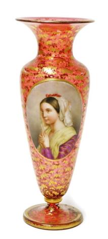 An early 20thC Vienna cranberry glass vase, with oval over painted panel depicting a maiden in purple and yellow dress, on a flared cranberry glass stem, with gilt floral decoration, 28cm high.