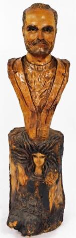 Willard Wigan M.B.E. (b.1957). Gianni Versace, a rustic carved head and torso portrait bust, over the Versace Medusa, carved into an integral natural tree trunk base, 150 cm high. Provenance: Commissioned for a designer clothes shop in Birmingham in 1997