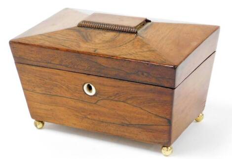 A Victorian mahogany sarcophagus tea caddy, the domed top with reeded bordering and a ivory key hole, with two lift up lids and red overall painted ground, on brass ball feet, 12cm high, 20cm wide, 13cm deep.