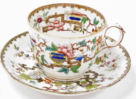 An early 20thC cup and saucer, in the Meissen style, decorated with flowers, leaves and urns, with a Greek key border, bearing red number to underside hand painted 7613, the saucer 17cm diameter, the cup 7cm high.