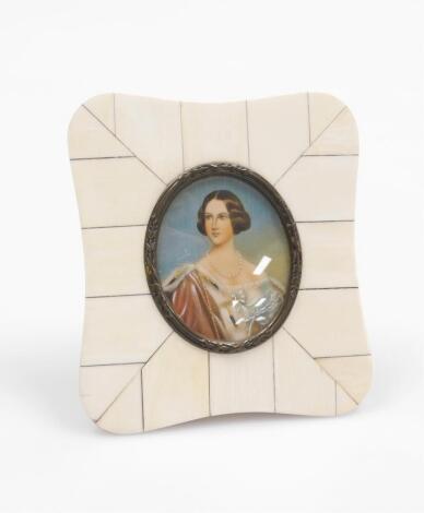 An early 19thC portrait miniature of a lady, the lady elaborately dressed, with necklace, painted on ivory and signed Esieth?, 6.5cm x 5cm, with oval metal surround, in an ivory tiled border, 12cm x 10cm.