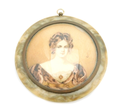 An early 19thC portrait miniature of a lady, with brunette hair in brown dress, on a brown coloured border, painted on panel and signed Corday, 6.5cm diameter, with a brass frame, in a tortoiseshell case with applied floral decoration, 8cm wide.