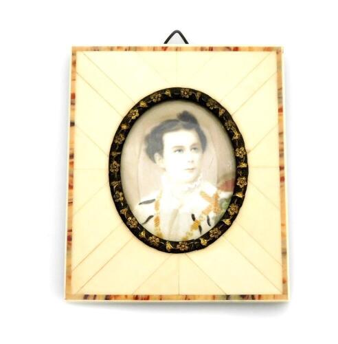 A late 19thC portrait miniature of a military gentleman, depicting a man in dress uniform possibly Ludwig II of Bavaria, signed Silas?, 3.5cm x 4.5cm, in a metal oval frame with applied floral decoration and ivory panelled border, with newspaper article b